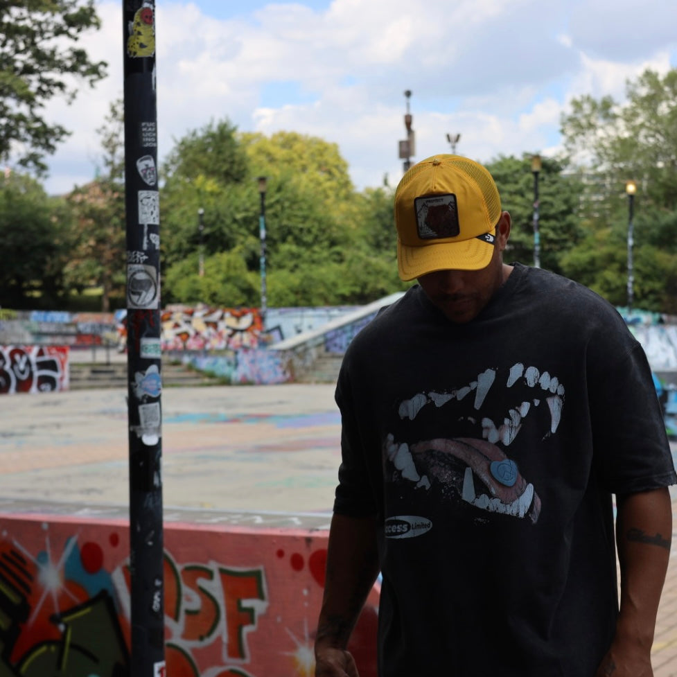 The Bite “Protect Inner Peace” Graphic Tee worn by a person in a vibrant skatepark setting.