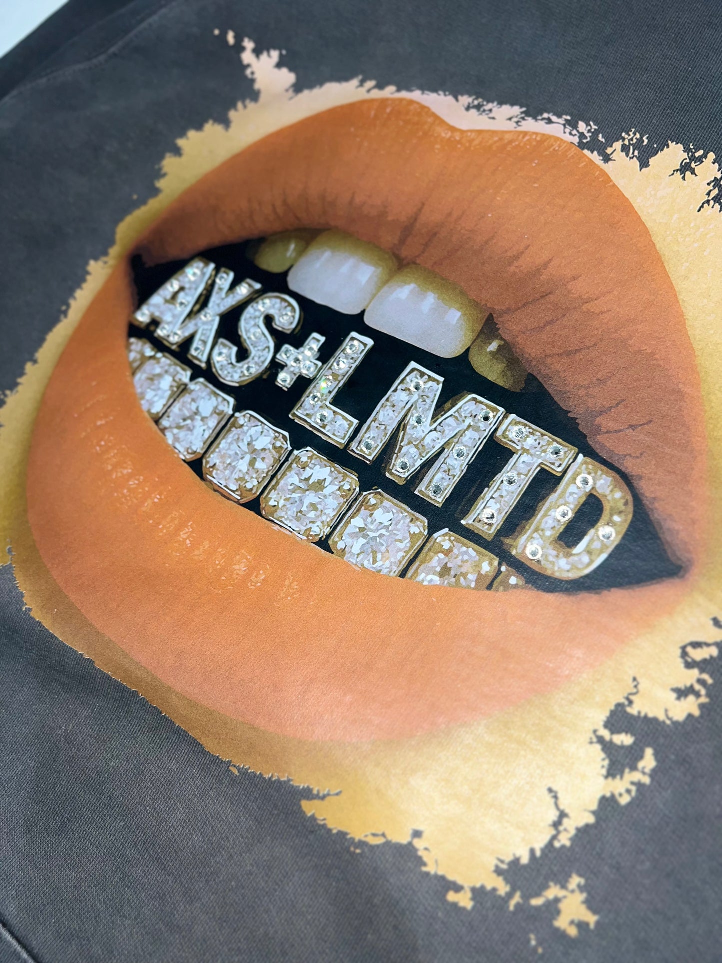 Lipstick with 'AKS+LMTD' text and diamond-like design on a dark background