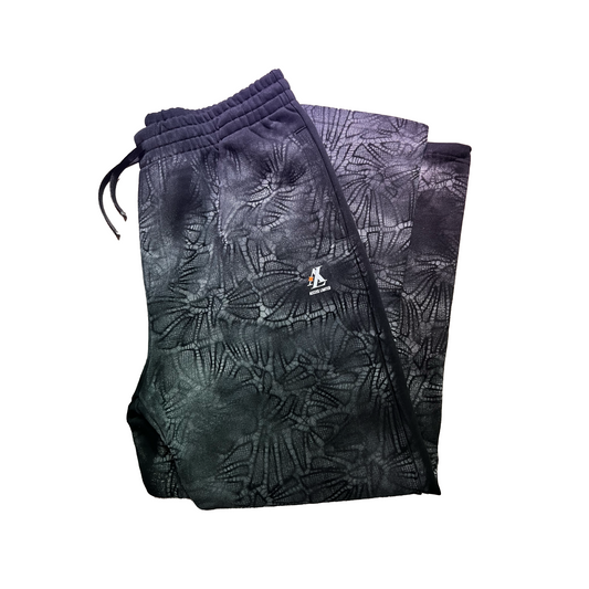 Folded black and gray patterned pants with a drawstring on a white background